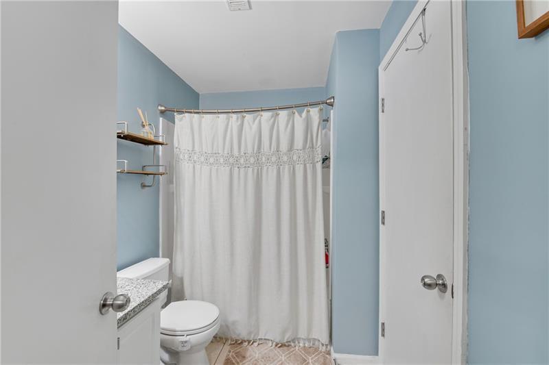 3655 Habersham Road Northeast, Unit 244B Atlanta, GA 30305 - Photo 19 of 34 a white toilet sitting next to a shower curtain