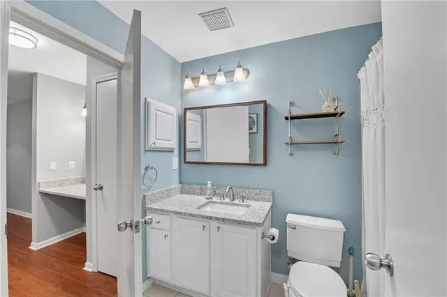 a bathroom with a toilet sink and mirror