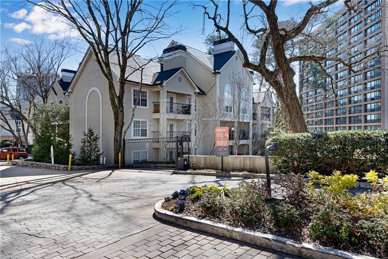 3655 Habersham Road Northeast, Unit 244B Atlanta, GA 30305 - Photo 26 of 34 a view of a white house with a large tree and flower plants