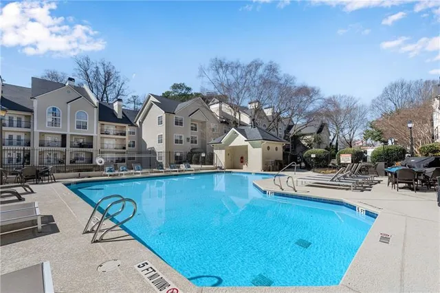 a view of a house with pool and sitting area