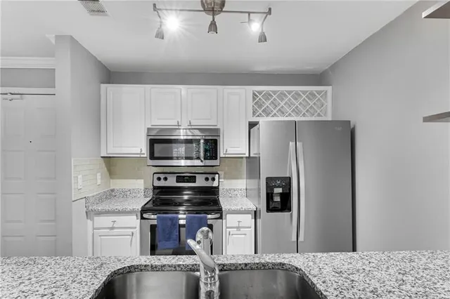 a kitchen with granite countertop a refrigerator stove and microwave