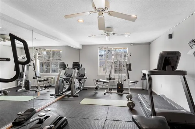 a room with gym equipment and large windows