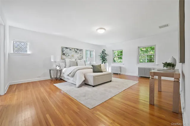 a bedroom with a large bed and wooden floor