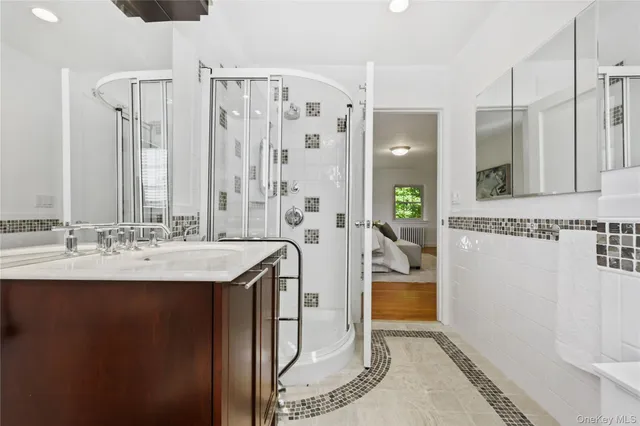 a en suite bathroom with a granite countertop sink and a mirror
