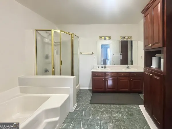 a bathroom with a tub sink and mirror