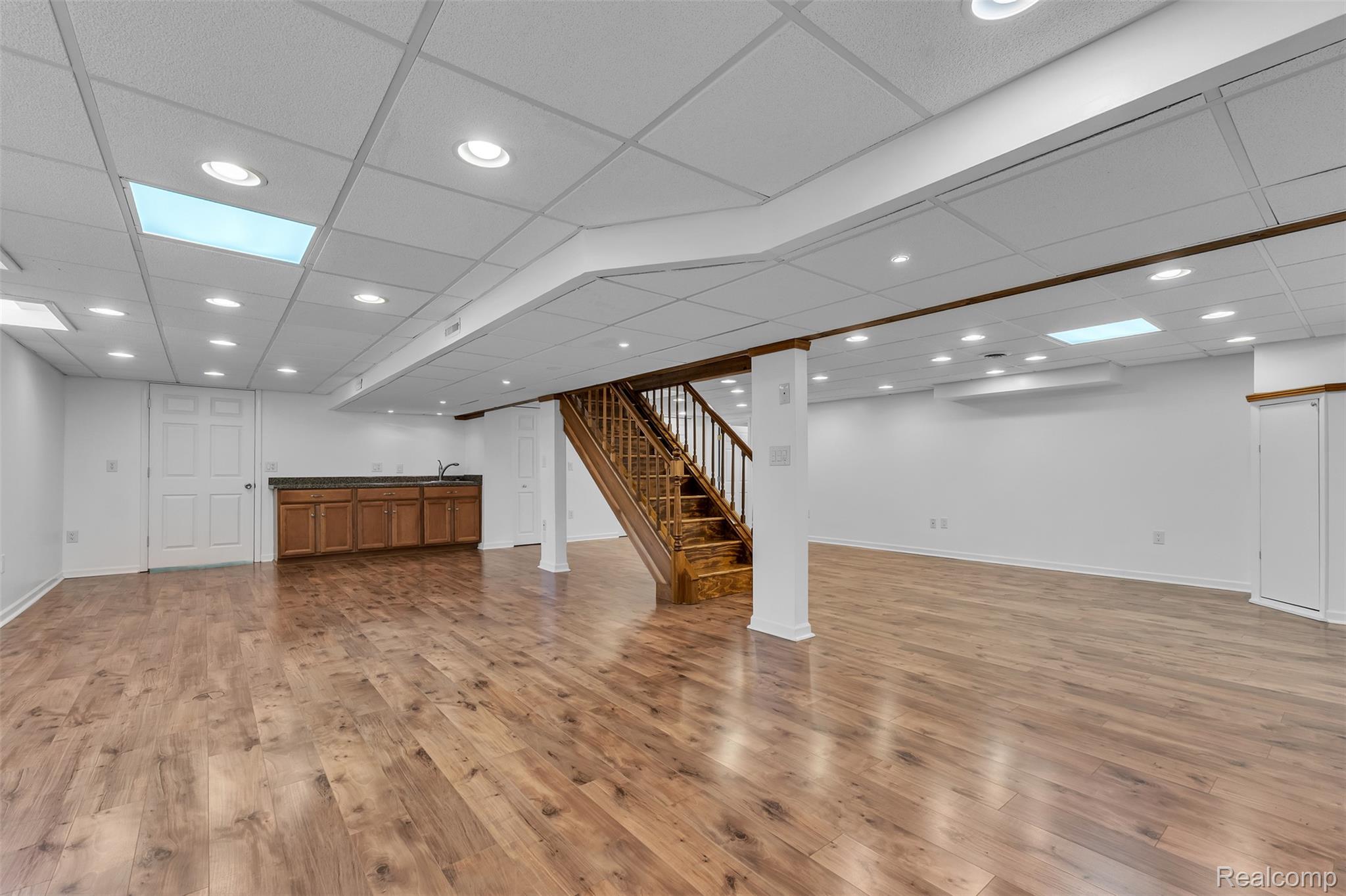 7000 Woonsocket Street Canton, MI 48187 - Photo 51 of 65 Spacious finished lower level featuring wood-finish flooring, recessed lighting, and a built-in wet bar with wood cabinetry and a double basin sink