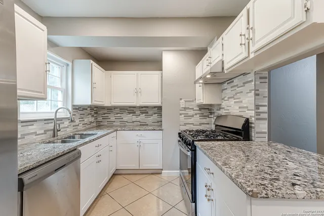 a kitchen with stainless steel appliances granite countertop a sink stove and cabinets