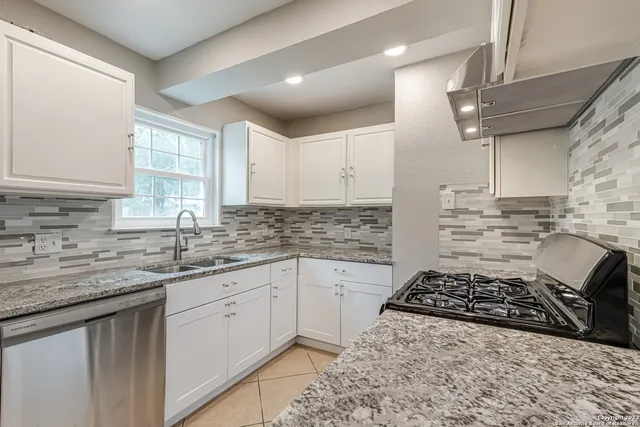 a kitchen with stainless steel appliances granite countertop a sink stove and cabinets