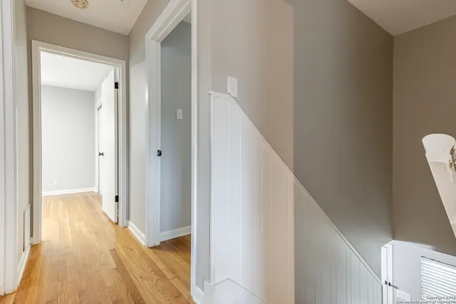 a view of a hallway with wooden floor and staircase