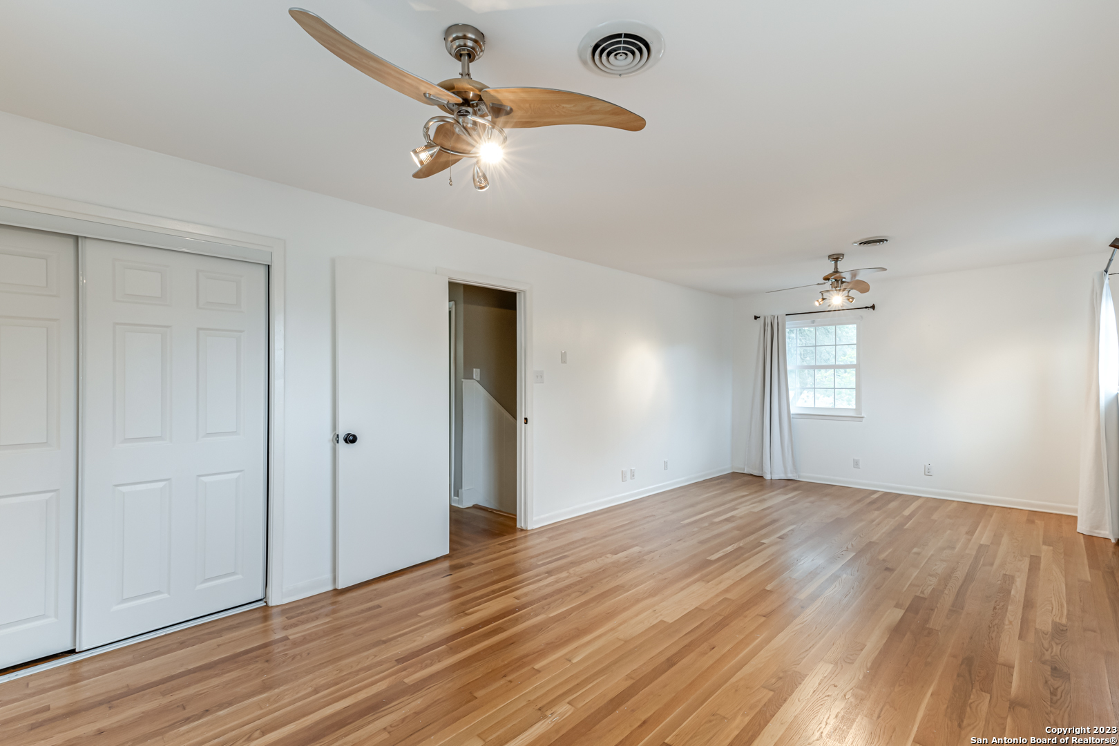 555 Patricia San Antonio, TX 78216 - Photo 28 of 33 an empty room with wooden floor chandelier fan and windows