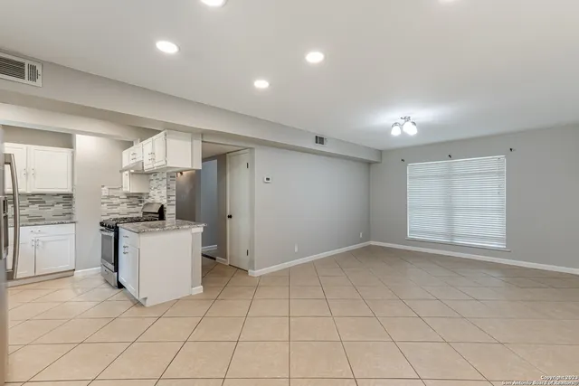 a kitchen with a refrigerator and white cabinets