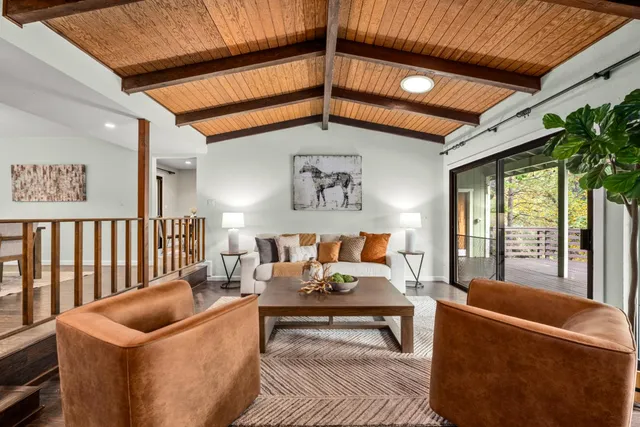 a kitchen with stainless steel appliances granite countertop wooden cabinets a refrigerator a sink a stove a microwave and wooden floors