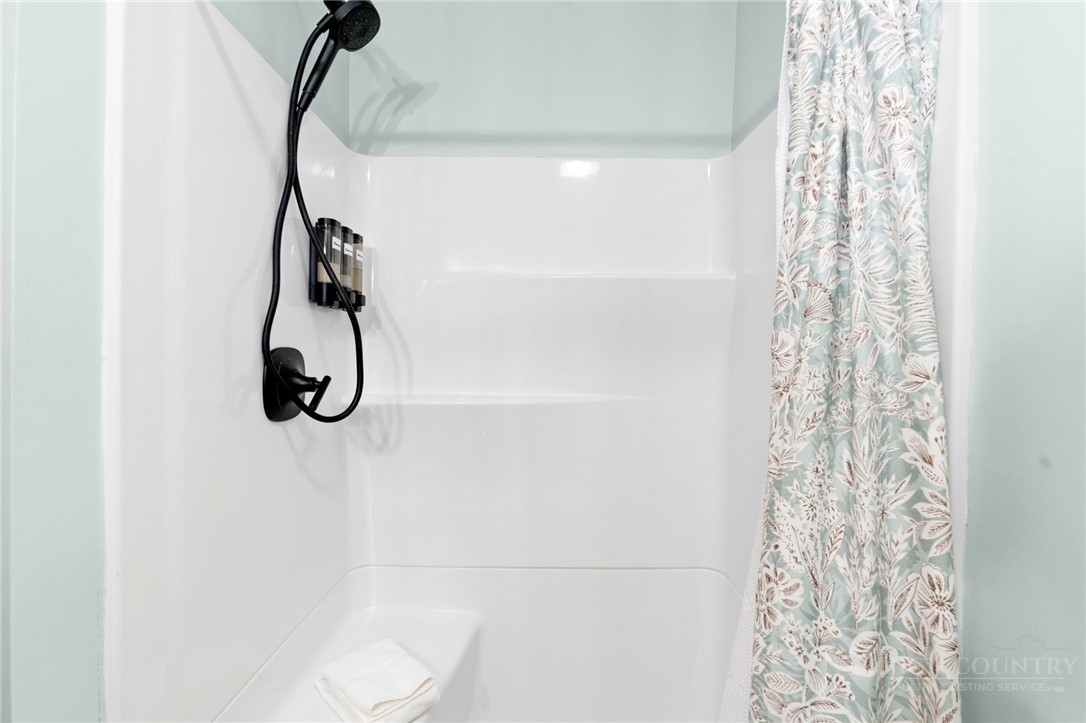 139 Golden Rod Loop Newland, NC 28657 - Photo 26 of 39 a bathroom with a shower curtain and a window
