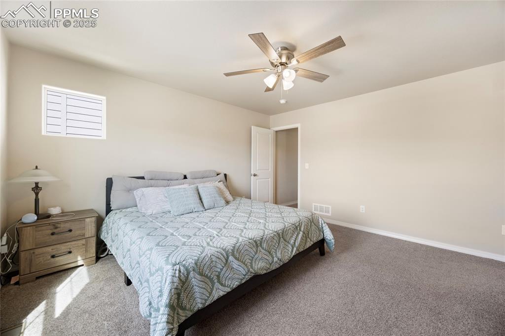 4536 Gneiss Loop Colorado Springs, CO 80938 - Photo 12 of 24 a bedroom with a bed and a chandelier