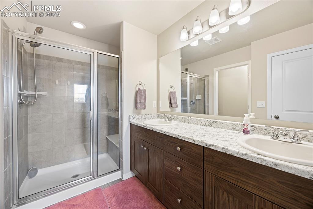 4536 Gneiss Loop Colorado Springs, CO 80938 - Photo 14 of 24 a bathroom with a double vanity sink mirror and shower