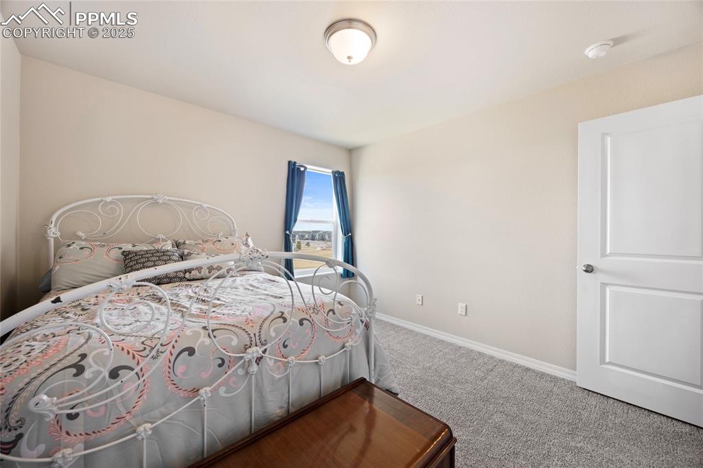 4536 Gneiss Loop Colorado Springs, CO 80938 - Photo 15 of 24 a bedroom with a bed and a lamp