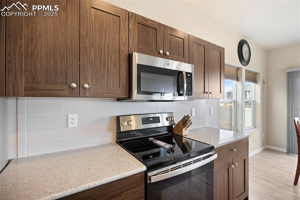 4536 Gneiss Loop Colorado Springs, CO 80938 - Photo 5 of 24 a kitchen with a stove and a microwave