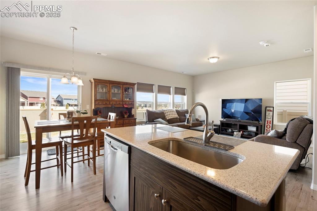 4536 Gneiss Loop Colorado Springs, CO 80938 - Photo 6 of 24 a kitchen with stainless steel appliances granite countertop a sink a stove and white cabinets