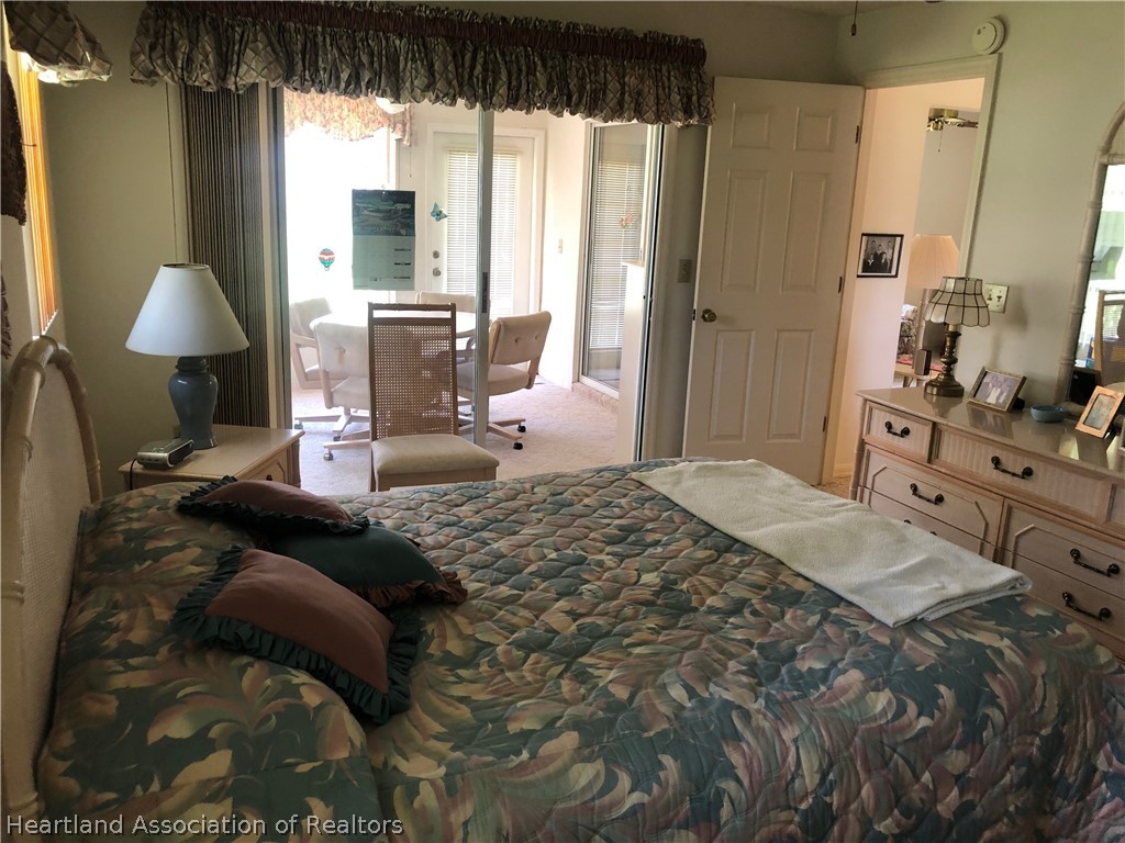 2510 Davis Circle Sebring, FL 33870 - Photo 9 of 23 a bedroom with a bed a lamp and window