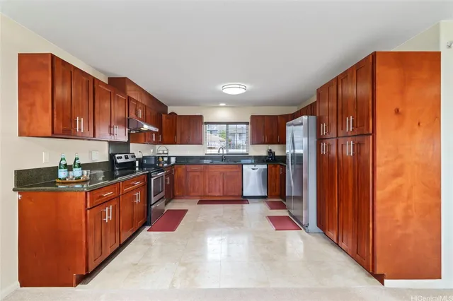 a large kitchen with stainless steel appliances granite countertop a refrigerator and a stove top oven