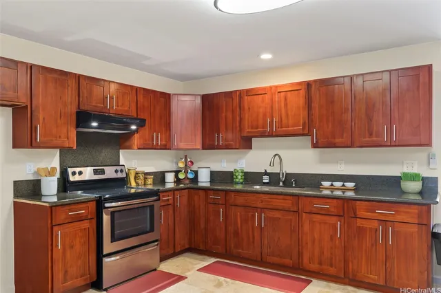 a kitchen with granite countertop wooden cabinets stainless steel appliances and a sink