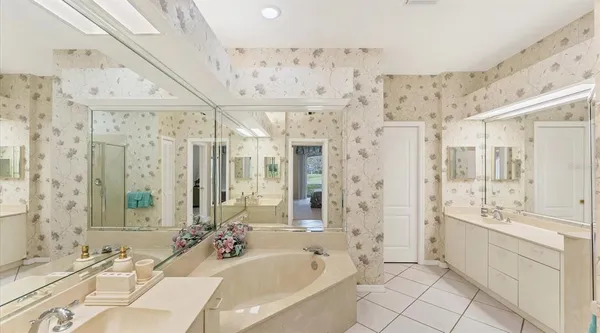 a bathroom with a bathtub shower sink mirror and double