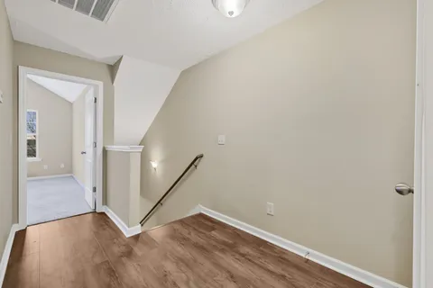 a view of a hallway with wooden floor