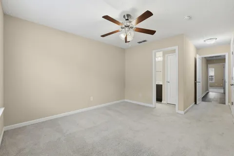 wooden floor in an empty room and a ceiling fan