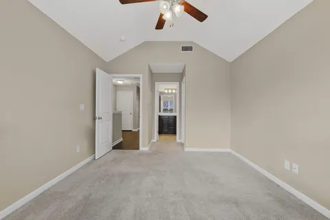 an empty room with a window and a ceiling fan