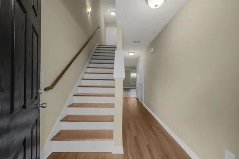 a view of entryway and hall with wooden floor