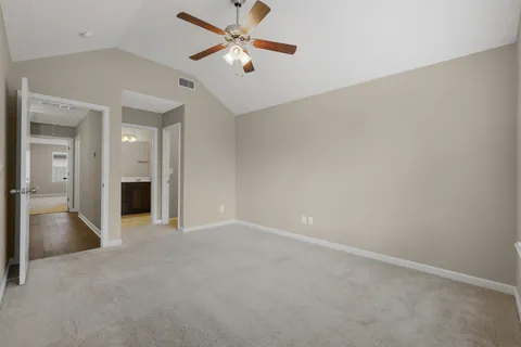 an empty room with closet and a ceiling fan