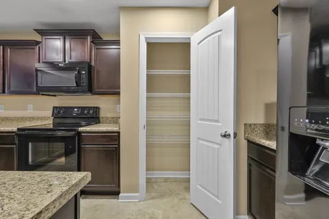 a kitchen with stainless steel appliances granite countertop a stove refrigerator and microwave