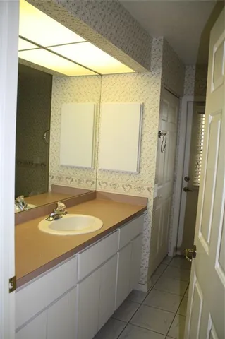 a bathroom with a granite countertop sink and a mirror