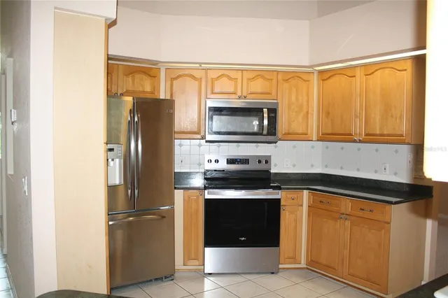 a kitchen with a refrigerator stove and microwave