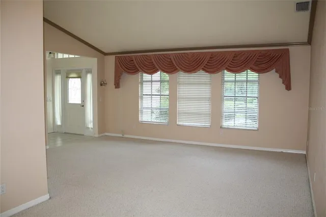 a view of an empty room with a fireplace and a large window