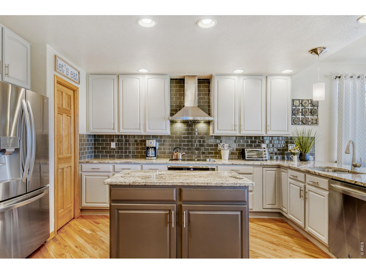 6350 Wier Way Arvada, CO 80403 - Photo 12 of 38 a kitchen with kitchen island granite countertop a sink cabinets and stainless steel appliances