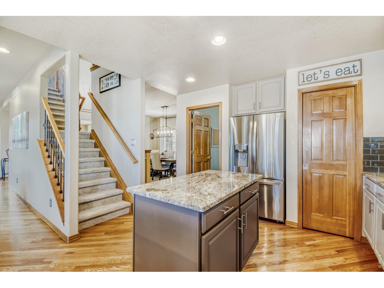 6350 Wier Way Arvada, CO 80403 - Photo 15 of 38 a kitchen with a stove a refrigerator and wooden floor