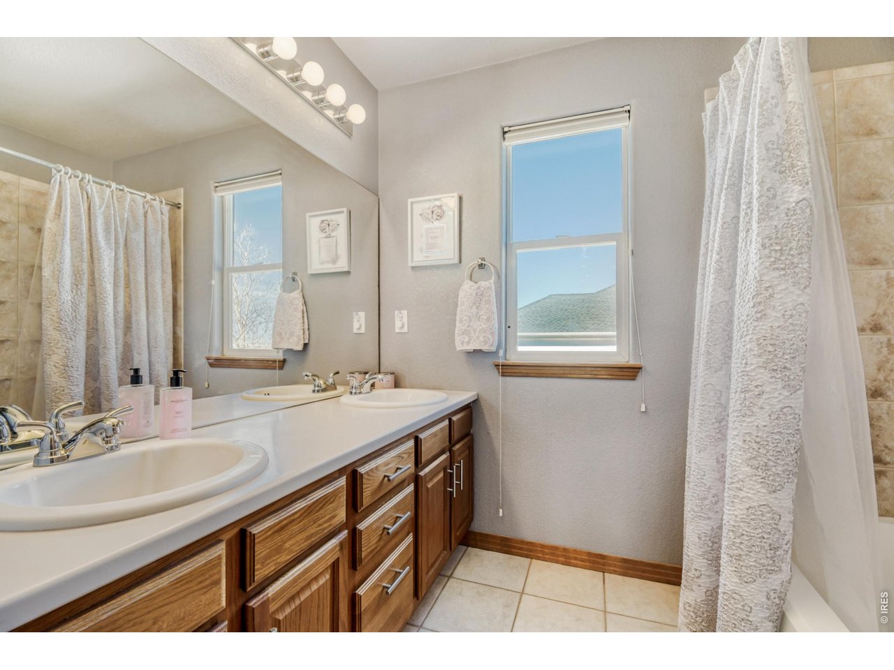 6350 Wier Way Arvada, CO 80403 - Photo 29 of 38 a bathroom with a sink a mirror and a shower