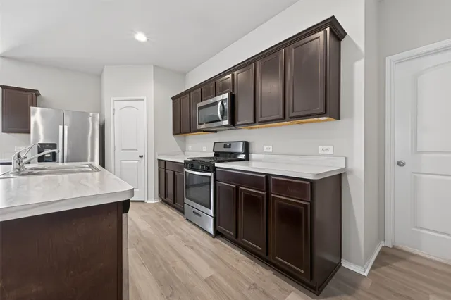 a kitchen with stainless steel appliances granite countertop a sink stove and microwave