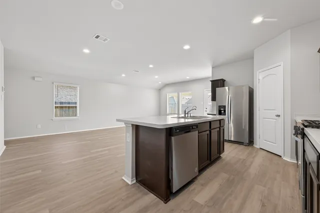a large kitchen with stainless steel appliances granite countertop a large counter top and wooden floor