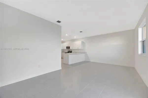 a view of a kitchen with a sink and dishwasher with white walls