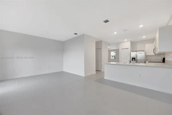 a view of kitchen with kitchen island white cabinets and wooden floor