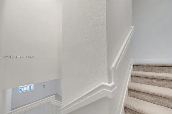 a view of staircase with white walls and empty racks
