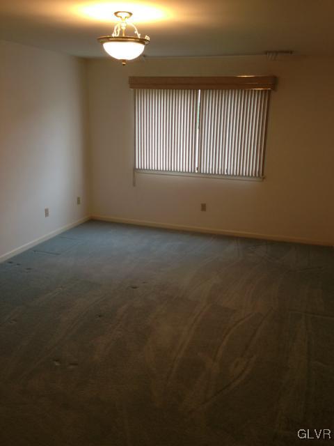 853 Cold Spring Road Allentown, PA 18103 - Photo 19 of 27 an empty room with a chandelier fan and windows