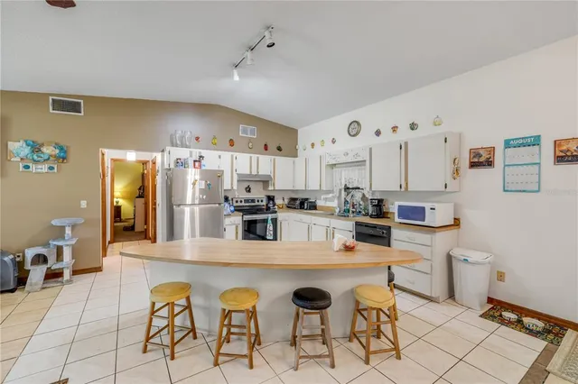 a kitchen with white cabinets stainless steel appliances