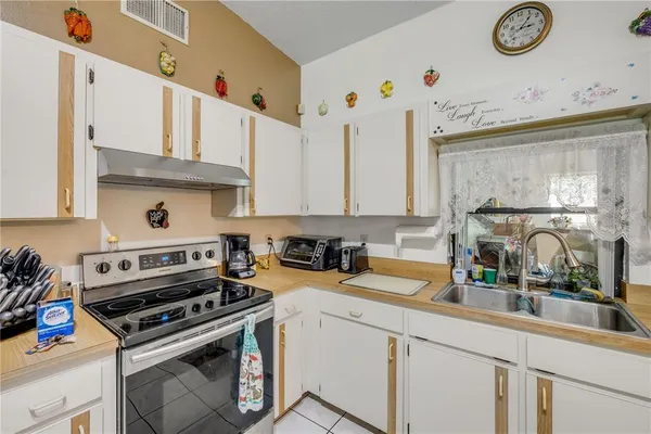 a view of a dining room with furniture a chandelier and a large window