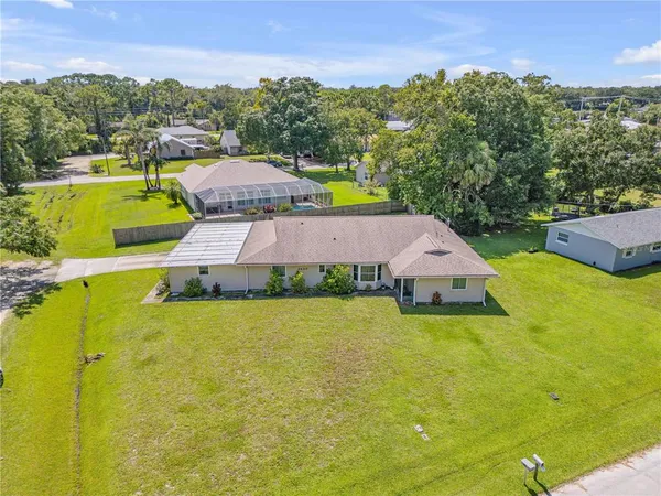 a view of a house with pool and a yard