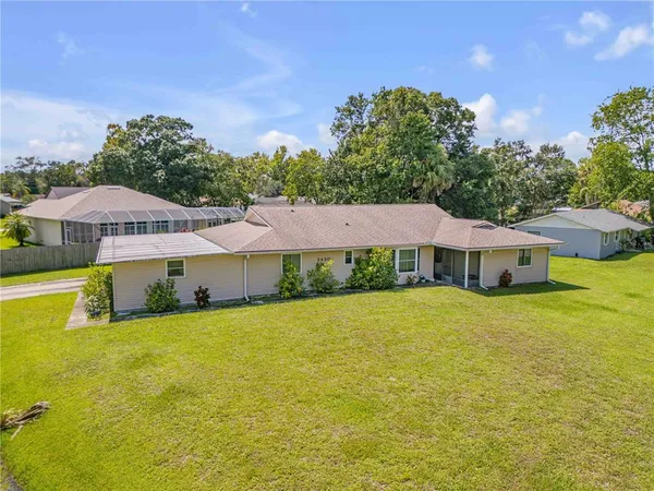 a view of a house with a big yard and a large tree
