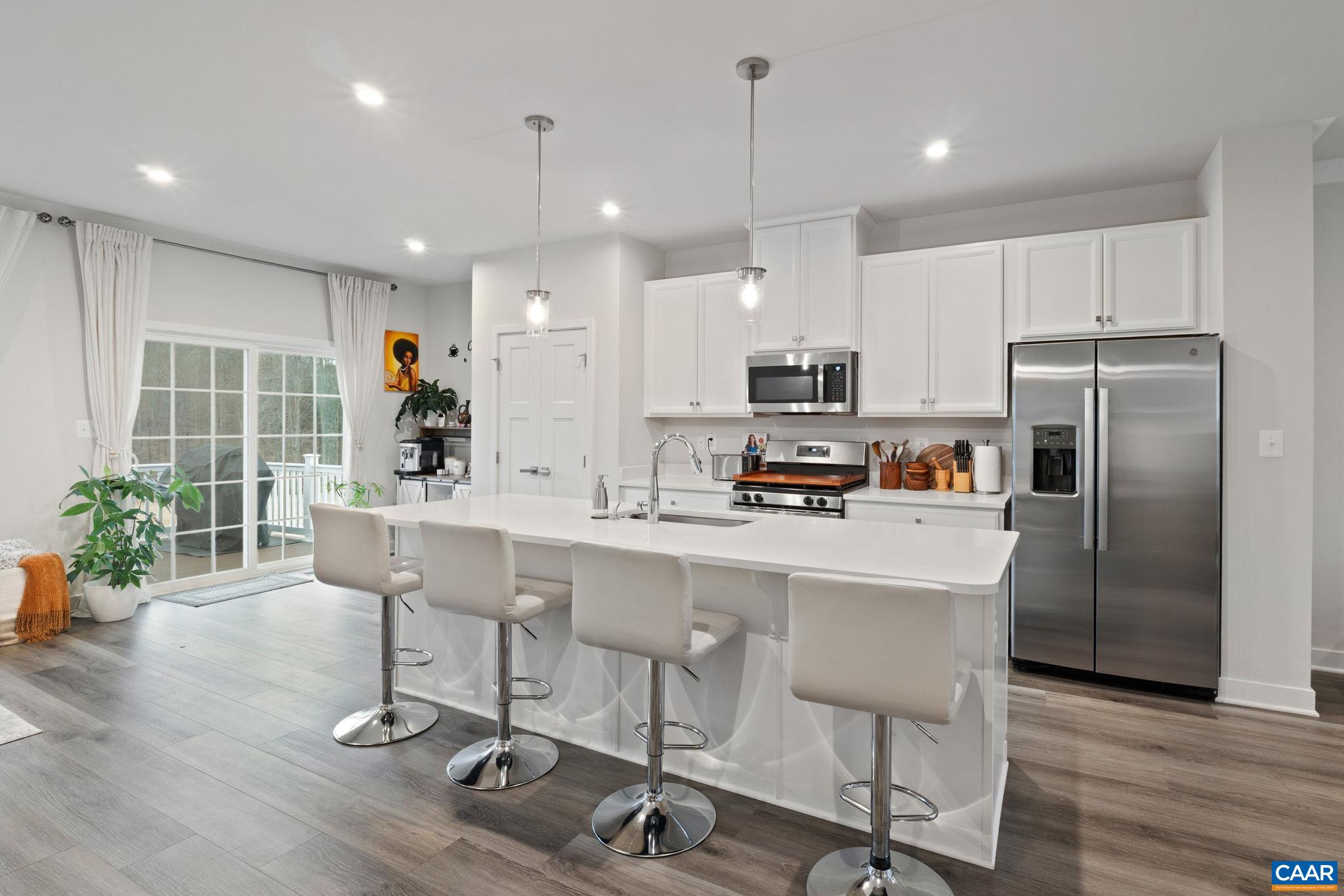 2402 Crescent Way Charlottesville, VA 22911 - Photo 16 of 27 Modern kitchen featuring a large center island with seating, stainless steel appliances, and ample cabinetry—ideal for both cooking and entertaining.