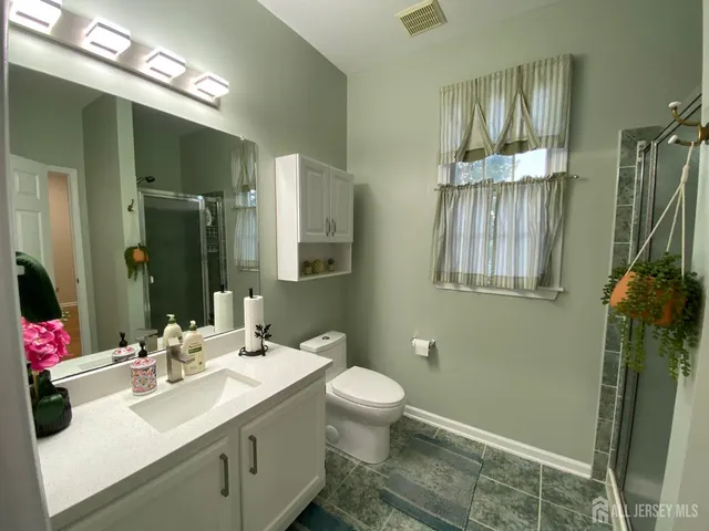 a bathroom with a sink vanity granite and a mirror